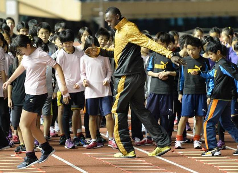 Usain Bolt come un vero coach insegna  ai bambini le basi dell&#39;atletica. Afp